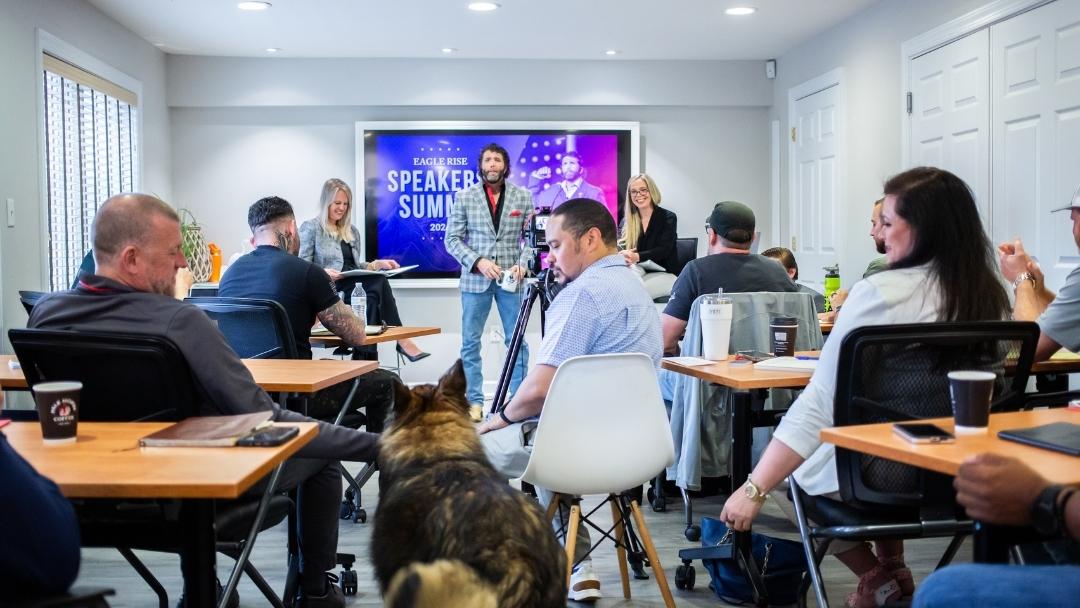 Engaging speaker leading interactive Eagle Rise Speakers Summit workshop with seated attendees — how to make a corporate event memorable and impactful.